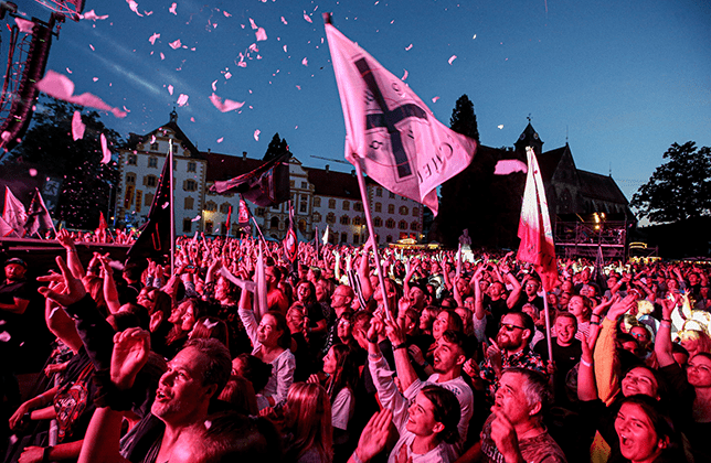 Konzertbühne vor dem beleuchteten Schloss Salem bei einer Abendveranstaltung.