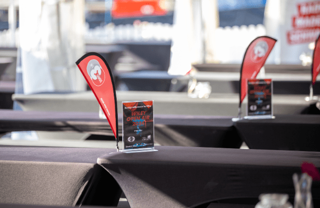 Rote Fähnchen mit Wiley Open Air Logo auf schwarzen Tischen 